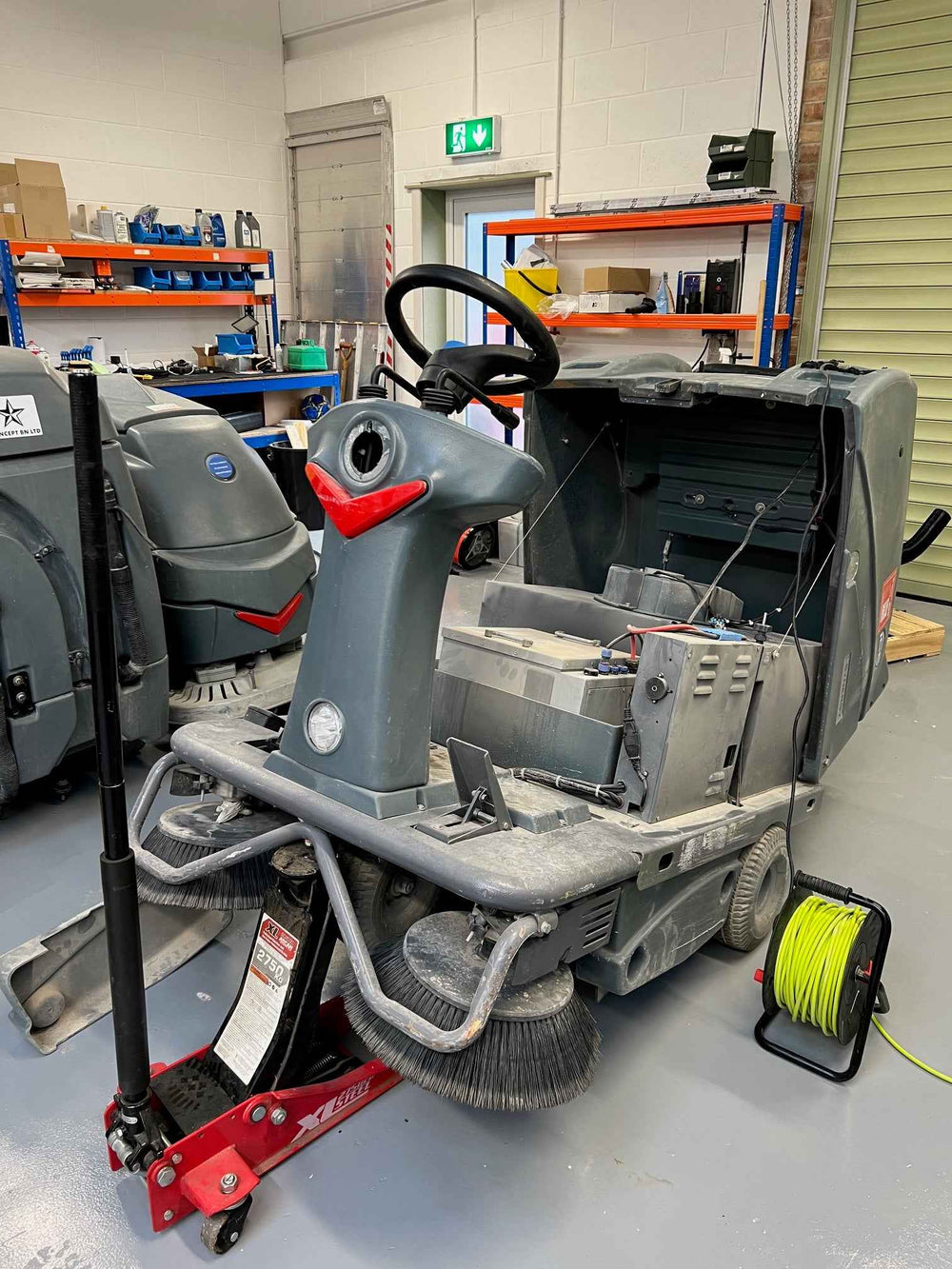A ride-on cleaning machine opened up for repair in the CCM workshop